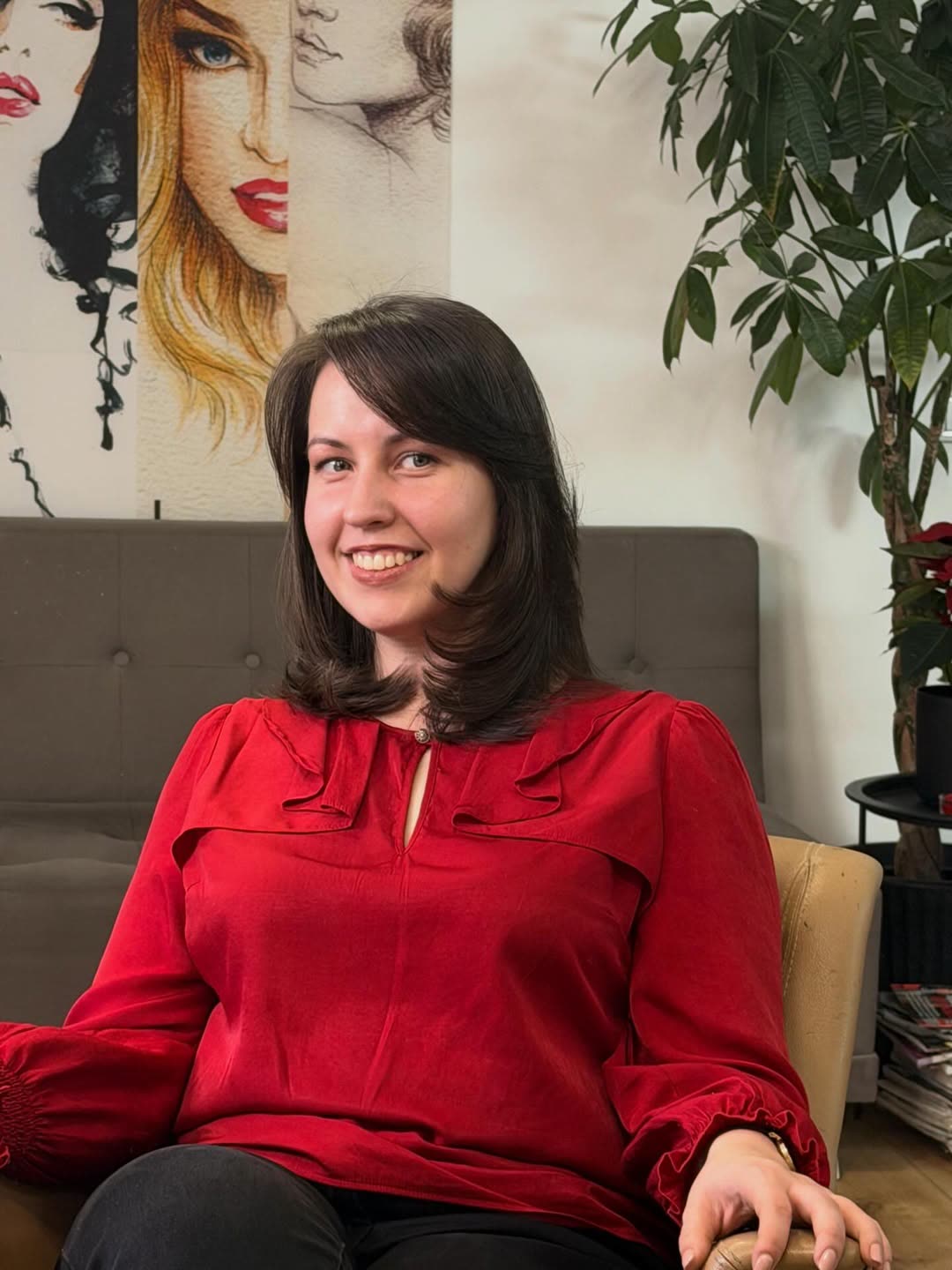 Clientă în roșu, cu părul închis la culoare, tuns până la umeri